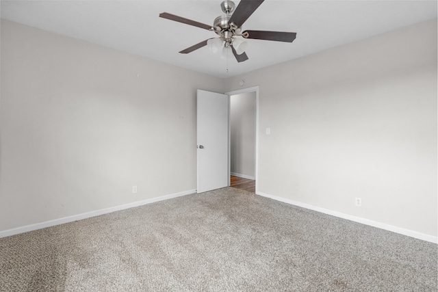 carpeted spare room featuring ceiling fan