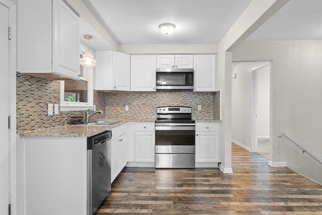 kitchen featuring stainless steel appliances, dark hardwood / wood-style flooring, pendant lighting, sink, and white cabinets