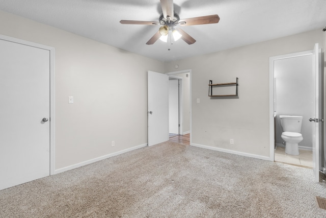 unfurnished bedroom featuring ensuite bathroom, ceiling fan, and carpet flooring