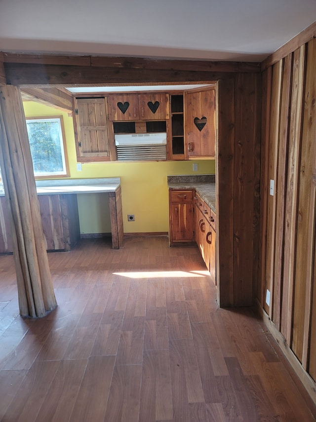 kitchen with dark wood-type flooring and wood walls