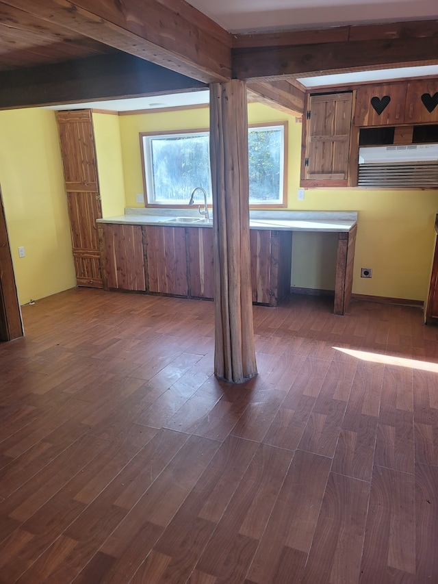 kitchen featuring beamed ceiling, dark hardwood / wood-style floors, and sink