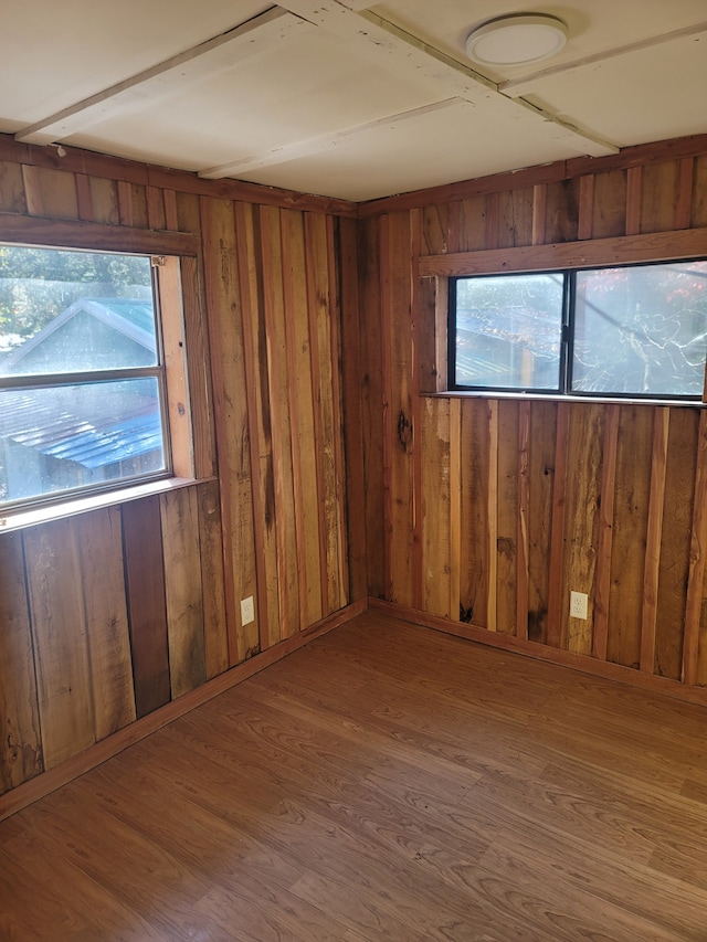 unfurnished room featuring wooden walls and hardwood / wood-style floors