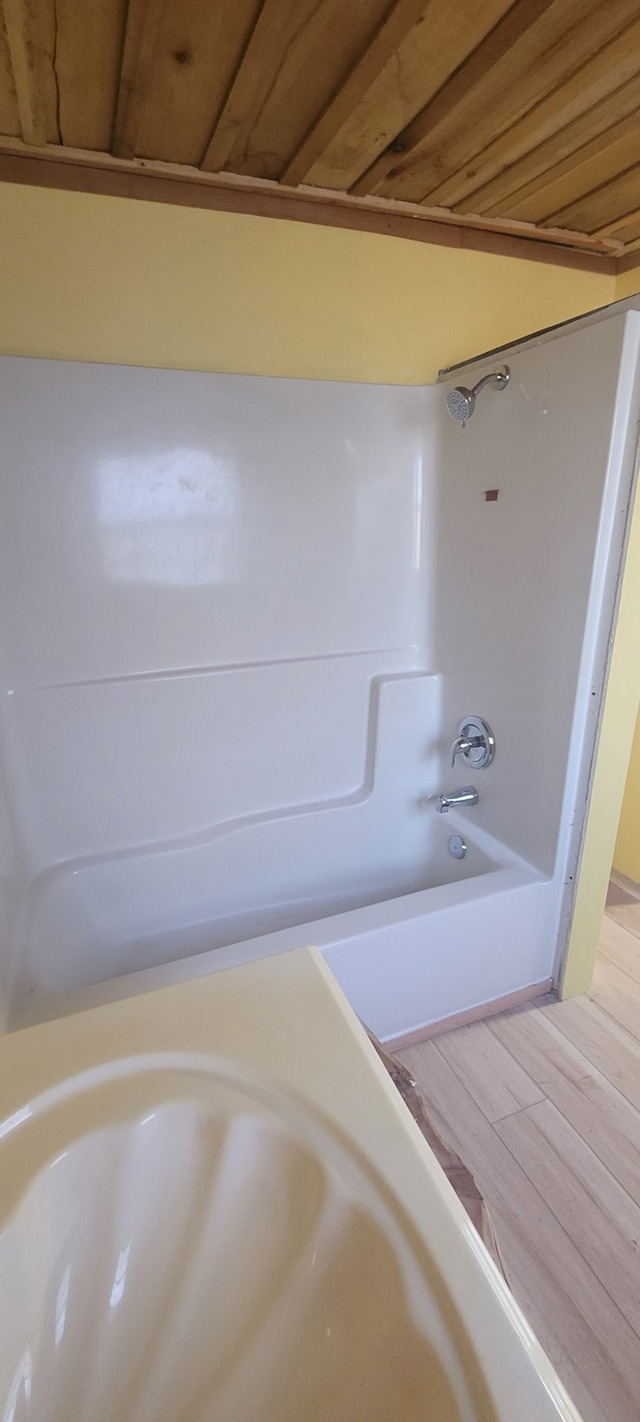 bathroom with hardwood / wood-style floors, shower / tub combination, and wood ceiling