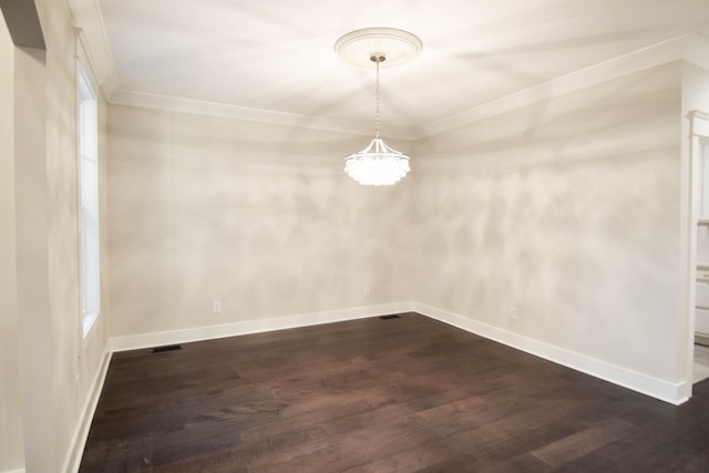 spare room with ornamental molding, dark wood-style flooring, and baseboards