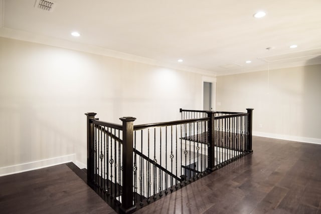 hallway with wood finished floors, visible vents, an upstairs landing, baseboards, and attic access