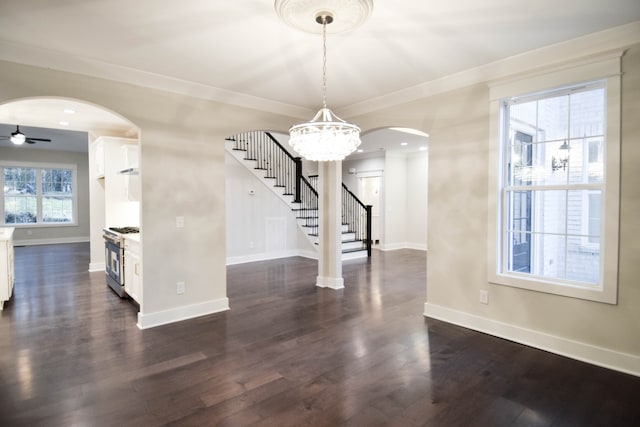 interior space with dark wood-style floors, ornamental molding, baseboards, and stairs