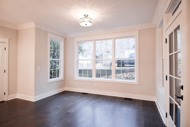 unfurnished room with visible vents, baseboards, dark wood-type flooring, and ornamental molding