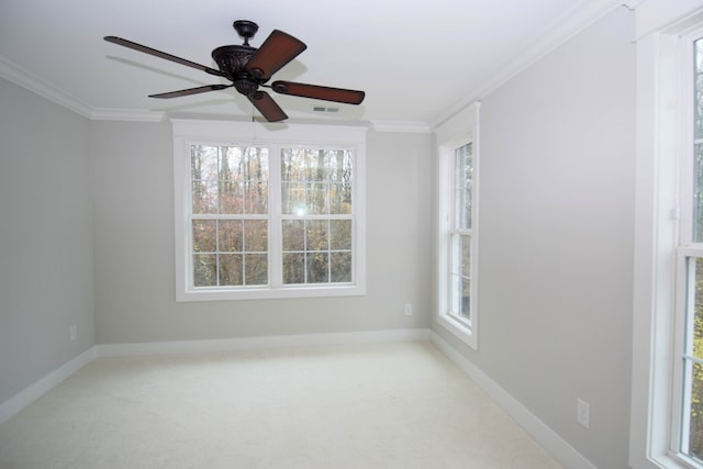 carpeted empty room featuring a ceiling fan, baseboards, visible vents, and crown molding