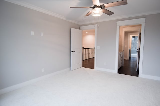 unfurnished bedroom with baseboards, carpet floors, ceiling fan, and crown molding