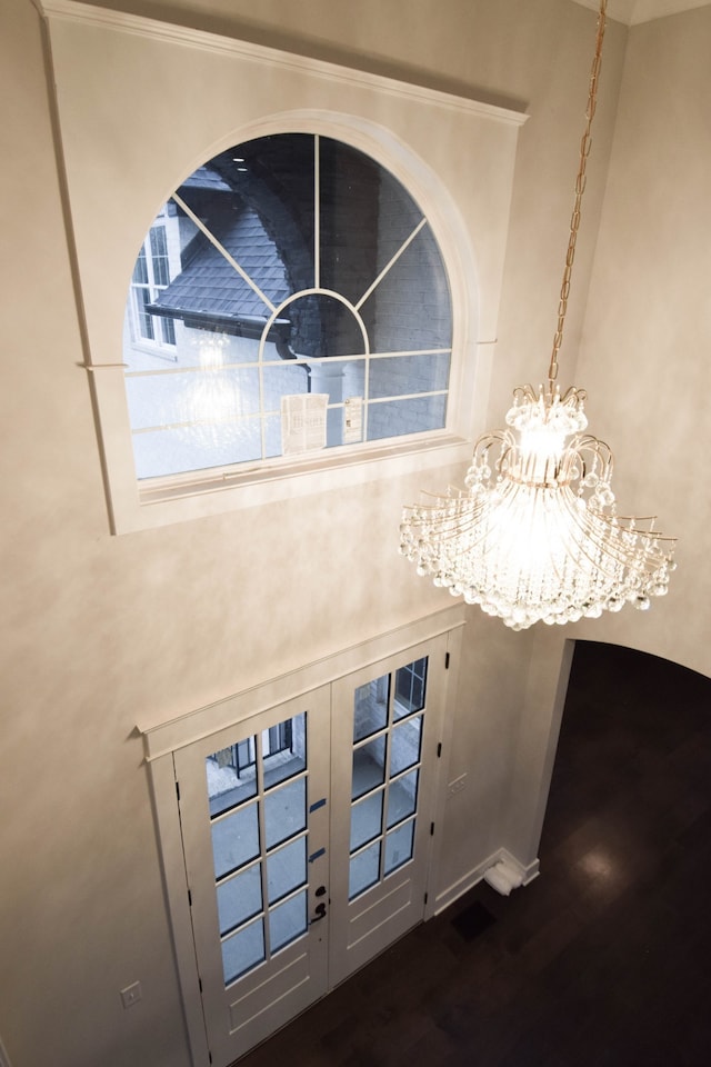 details with baseboards, an inviting chandelier, and wood finished floors