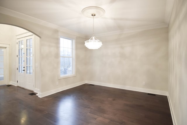 unfurnished dining area with arched walkways, dark wood-style flooring, baseboards, and crown molding