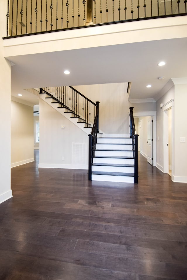 stairs with crown molding, baseboards, and wood finished floors