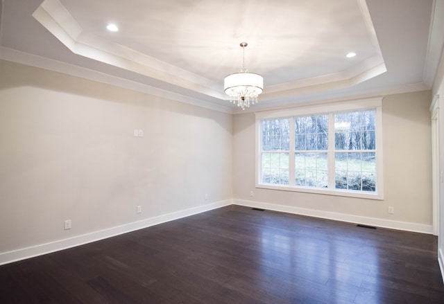 unfurnished room featuring a tray ceiling, visible vents, and dark wood finished floors