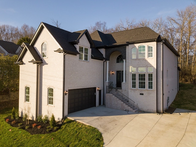 view of front of home featuring a garage, concrete driveway, and brick siding