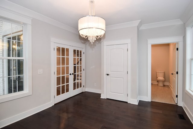 unfurnished dining area featuring dark wood-style floors, visible vents, crown molding, and french doors