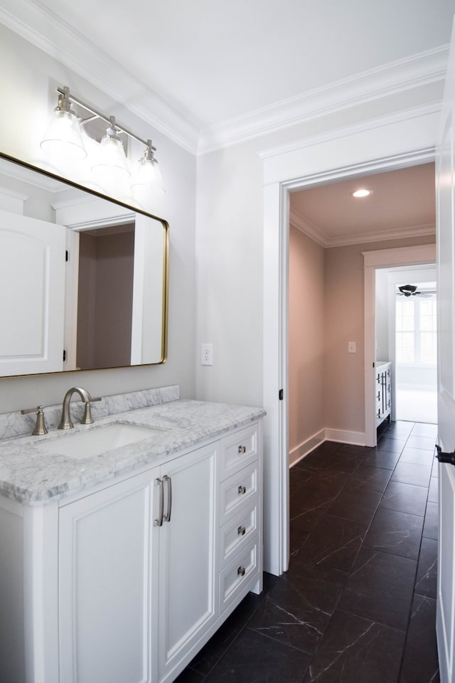 bathroom with baseboards, vanity, and crown molding