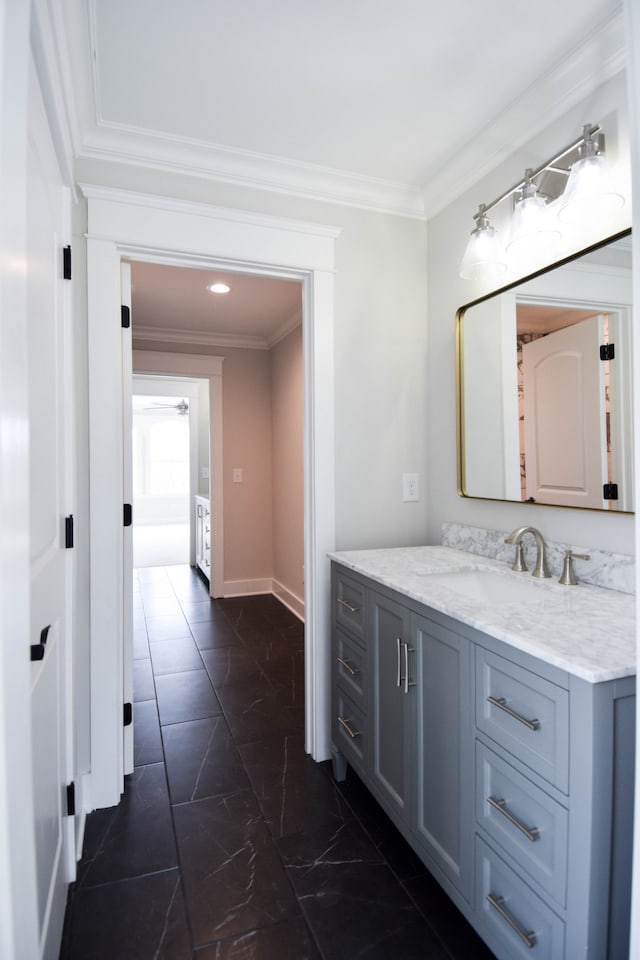 bathroom with marble finish floor, baseboards, crown molding, and vanity