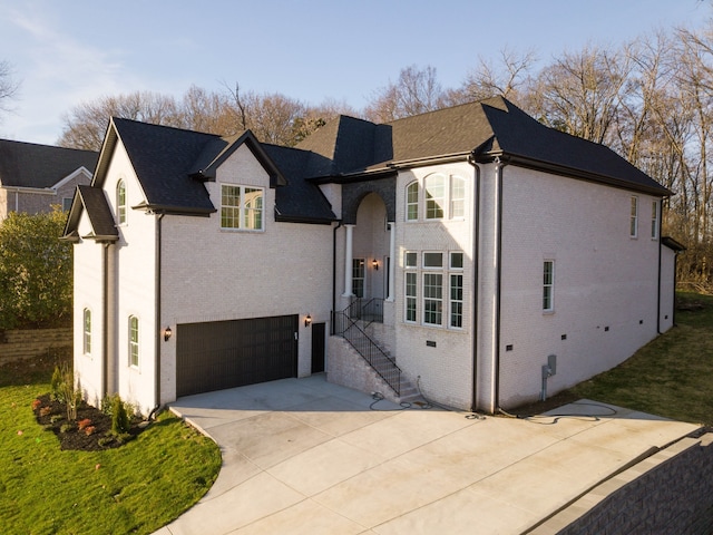 view of front facade with driveway, a garage, and brick siding