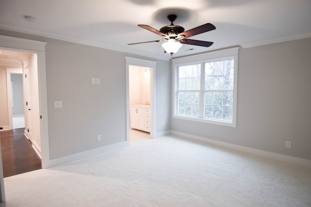 carpeted bedroom featuring a ceiling fan, baseboards, ornamental molding, and connected bathroom