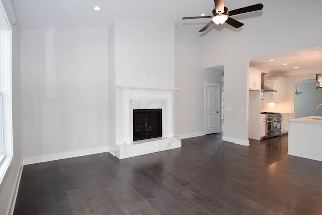 unfurnished living room with dark wood-style flooring, a fireplace, recessed lighting, ceiling fan, and baseboards