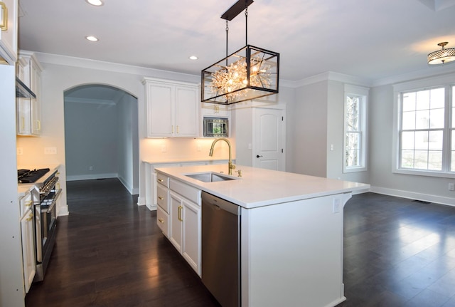 kitchen featuring arched walkways, light countertops, appliances with stainless steel finishes, ornamental molding, and a sink