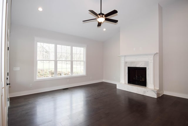 unfurnished living room with visible vents, dark wood finished floors, baseboards, and a premium fireplace