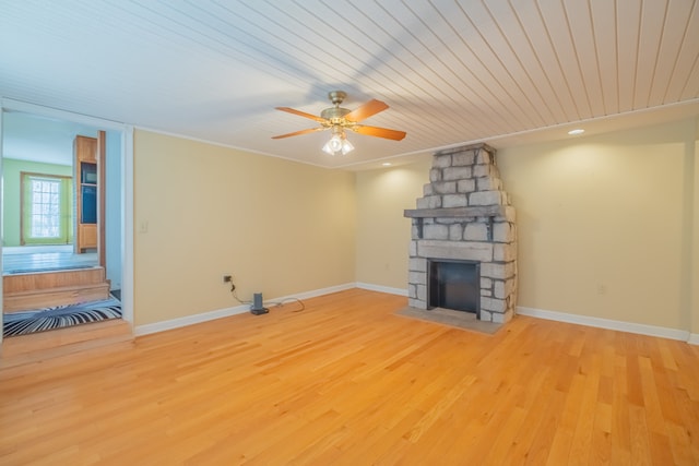 unfurnished living room featuring ornamental molding, ceiling fan, a fireplace, wood ceiling, and light hardwood / wood-style flooring