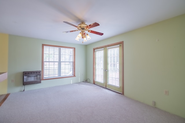 unfurnished living room featuring light carpet, ceiling fan, and heating unit