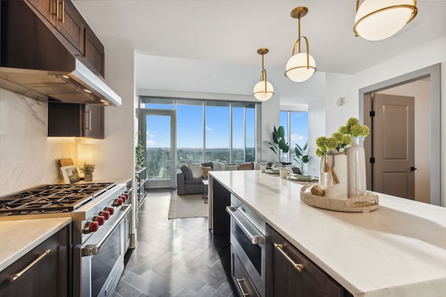 kitchen with dark brown cabinets, pendant lighting, decorative backsplash, premium range, and dark parquet flooring