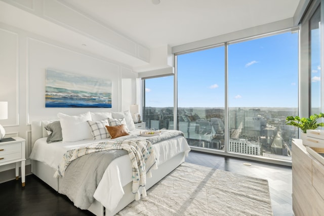 bedroom featuring a wall of windows and hardwood / wood-style flooring