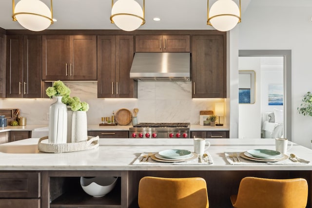 1616 W End Ave Unit 2911, Nashville, TN 37203 - kitchen with range hood, decorative light fixtures, dark brown cabinetry, and a breakfast bar