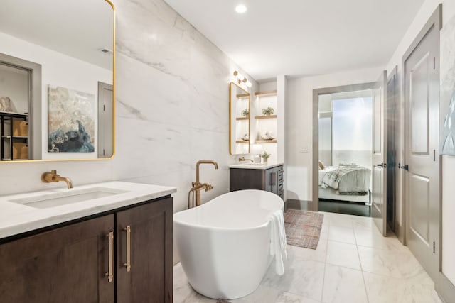 bathroom with tile walls, a washtub, and vanity