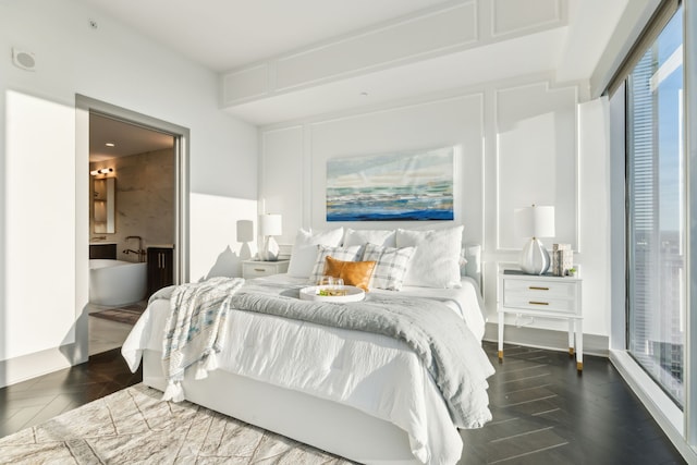 bedroom with dark hardwood / wood-style flooring and ensuite bath