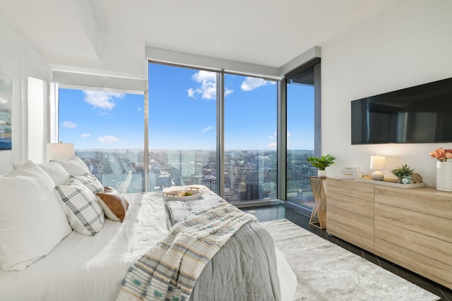 bedroom with hardwood / wood-style floors, multiple windows, and floor to ceiling windows