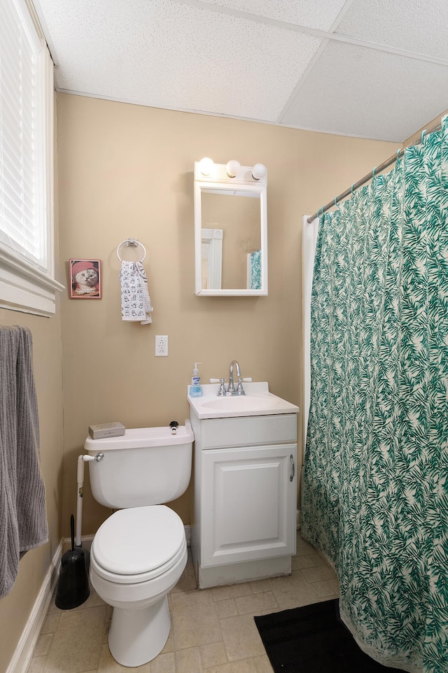 bathroom with toilet, vanity, and tile patterned flooring