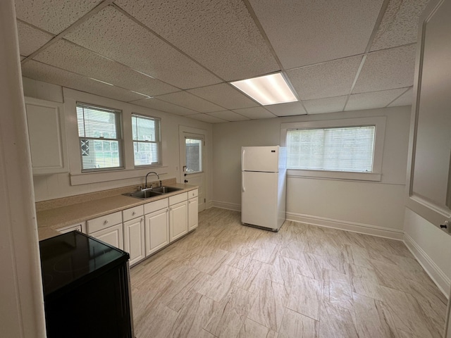 kitchen with range, a paneled ceiling, white fridge, and sink