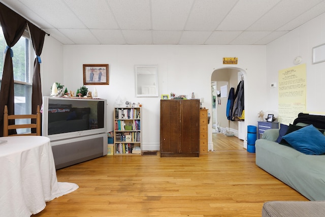 living room with light wood-type flooring and a drop ceiling