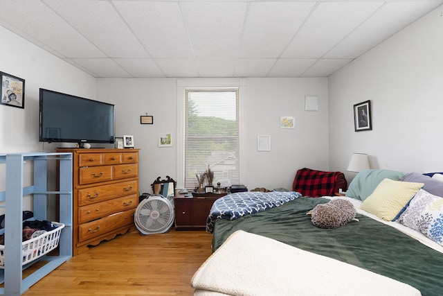 bedroom with a drop ceiling and hardwood / wood-style floors