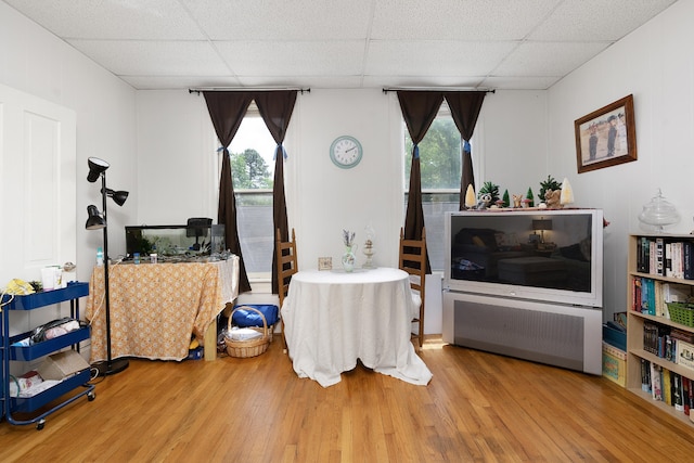 living room with a paneled ceiling and hardwood / wood-style flooring