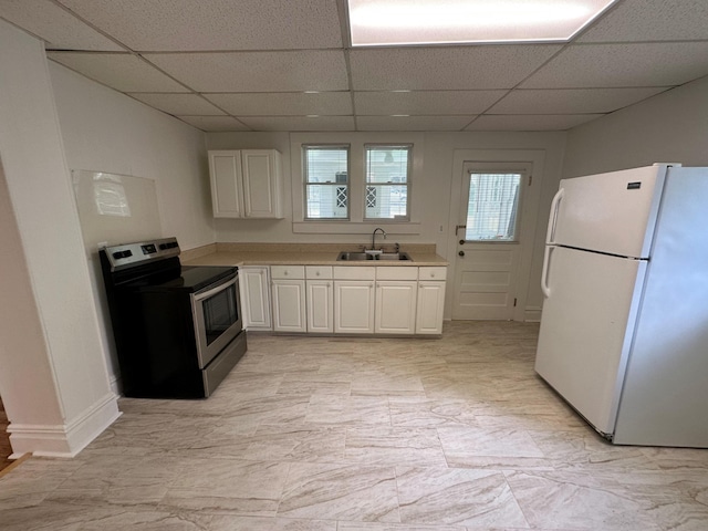 kitchen featuring sink, a drop ceiling, stainless steel electric range oven, white cabinets, and white refrigerator