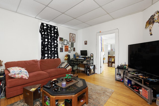 living room featuring a paneled ceiling and hardwood / wood-style floors