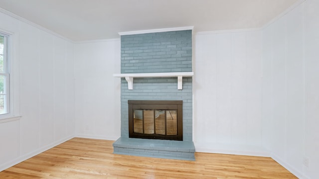 interior details featuring wood-type flooring, a brick fireplace, and crown molding