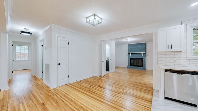 interior space with ornamental molding, light hardwood / wood-style floors, a healthy amount of sunlight, and a fireplace