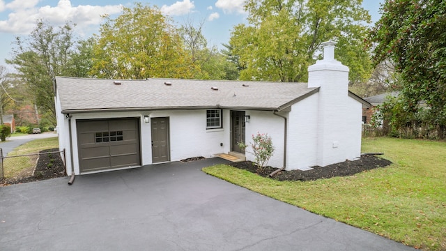 ranch-style house featuring a garage and a front yard