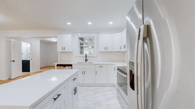 kitchen with white cabinetry, sink, backsplash, and appliances with stainless steel finishes