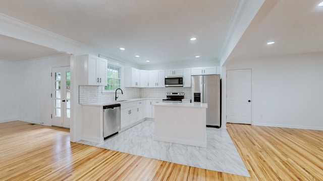 kitchen featuring a center island, white cabinets, light hardwood / wood-style floors, and stainless steel appliances