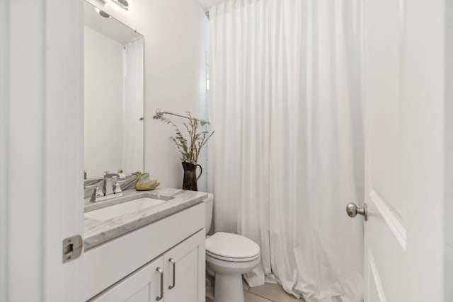 bathroom with toilet, vanity, and tile patterned floors