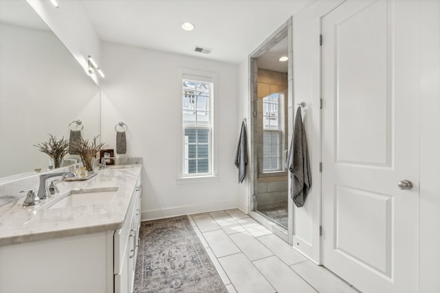 bathroom featuring walk in shower, tile patterned flooring, and vanity