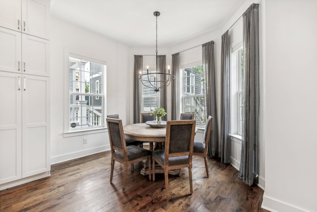 dining room with dark hardwood / wood-style floors and a chandelier