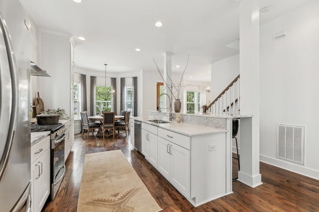 kitchen featuring white cabinets, a wealth of natural light, dark hardwood / wood-style floors, and appliances with stainless steel finishes